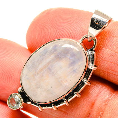 Oval rainbow moonstone pendant in 925 sterling silver with bezel surround and halo.
