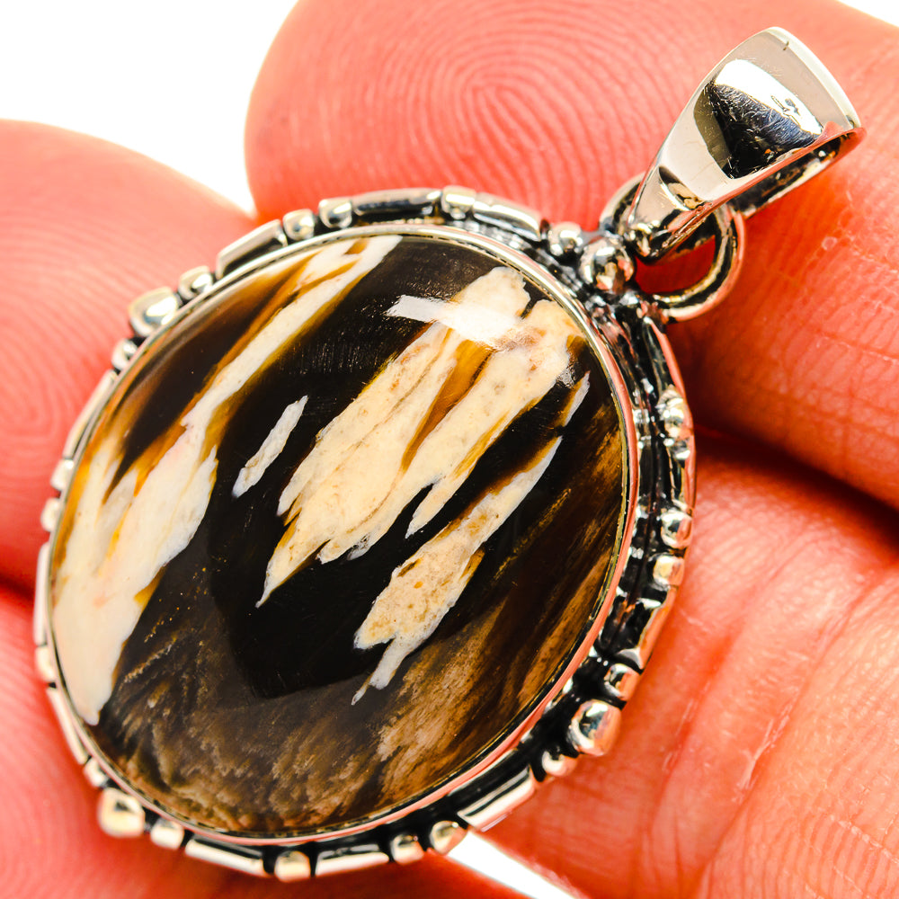 Oval jasper pendant in sterling silver with black, tan swirled stone and loop bail.