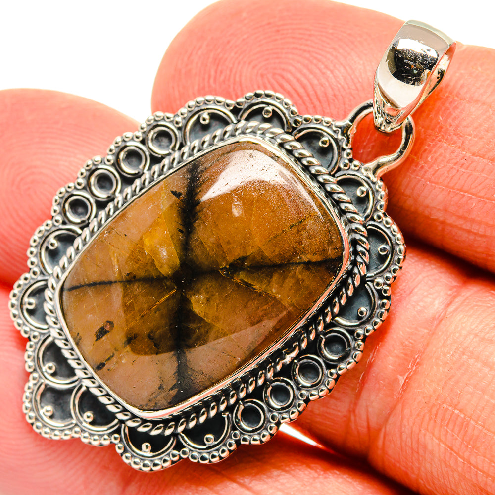 Chiastolite pendant with oval amber-gold stone in ornate 925 sterling silver border
