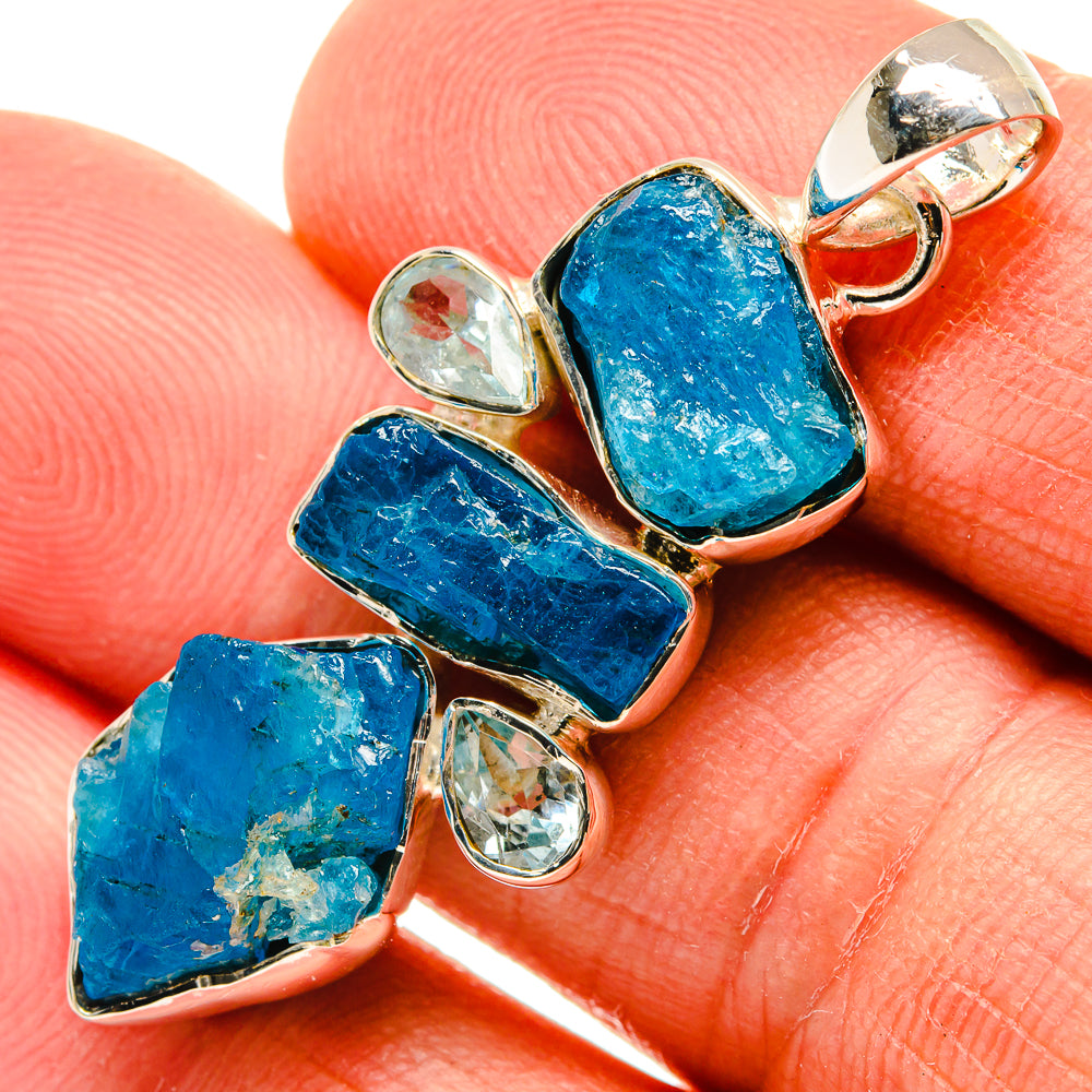 Sterling silver pendant with rough blue gemstone and clear accent stones, polished setting