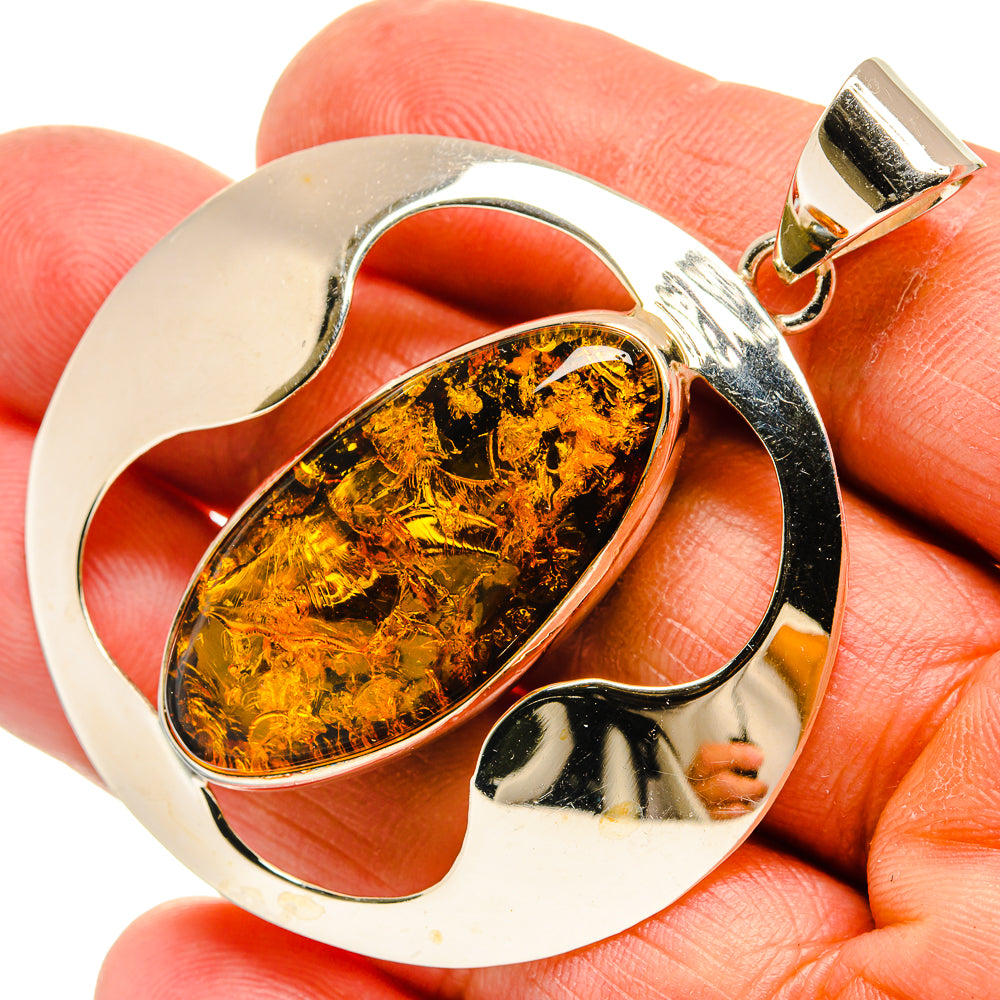Sterling silver amber pendant with oval Baltic amber stone in sculpted frame