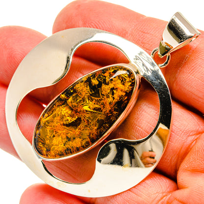 Sterling silver amber pendant with oval Baltic amber stone in sculpted frame