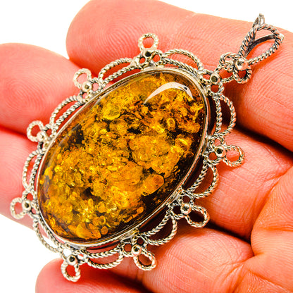 Oval Baltic amber cabochon pendant in silver bezel with chain-link frame and bail