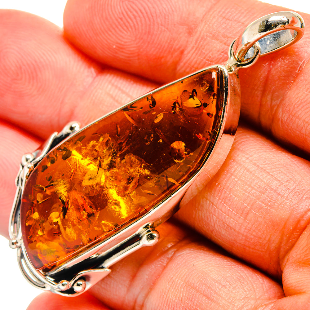 Amber teardrop pendant in 925 sterling silver with openwork bezel and bail