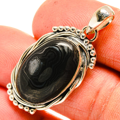 Close-up oval sterling silver psilomelane pendant with black-gray swirl stone and top loop