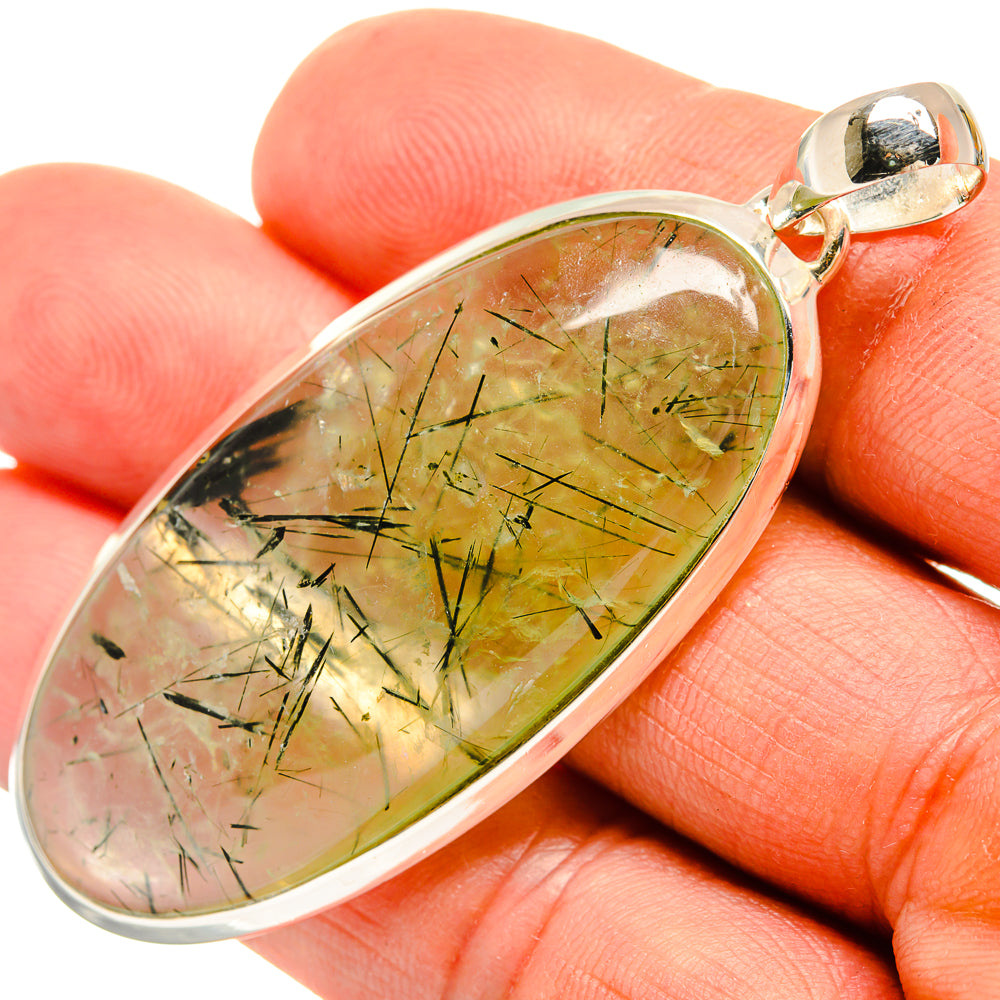 Oval prehnite pendant with green-gold needle inclusions on a silver bail