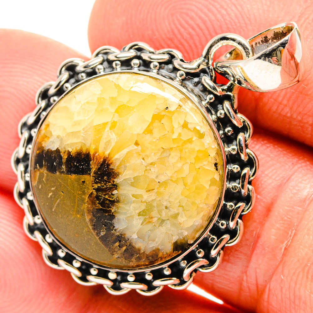 Close-up septarian pendant with faceted amber oval stone, black matrix, silver bail