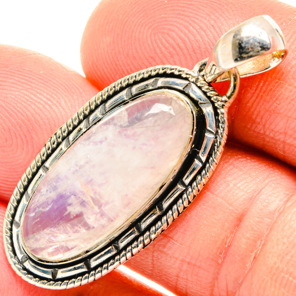 Oval moonstone pendant with ornate silver bezel and bail, pale pink iridescent stone