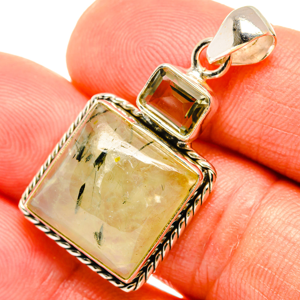 Green gemstone pendant detail with square bezel, decorative silver edging, and top bail
