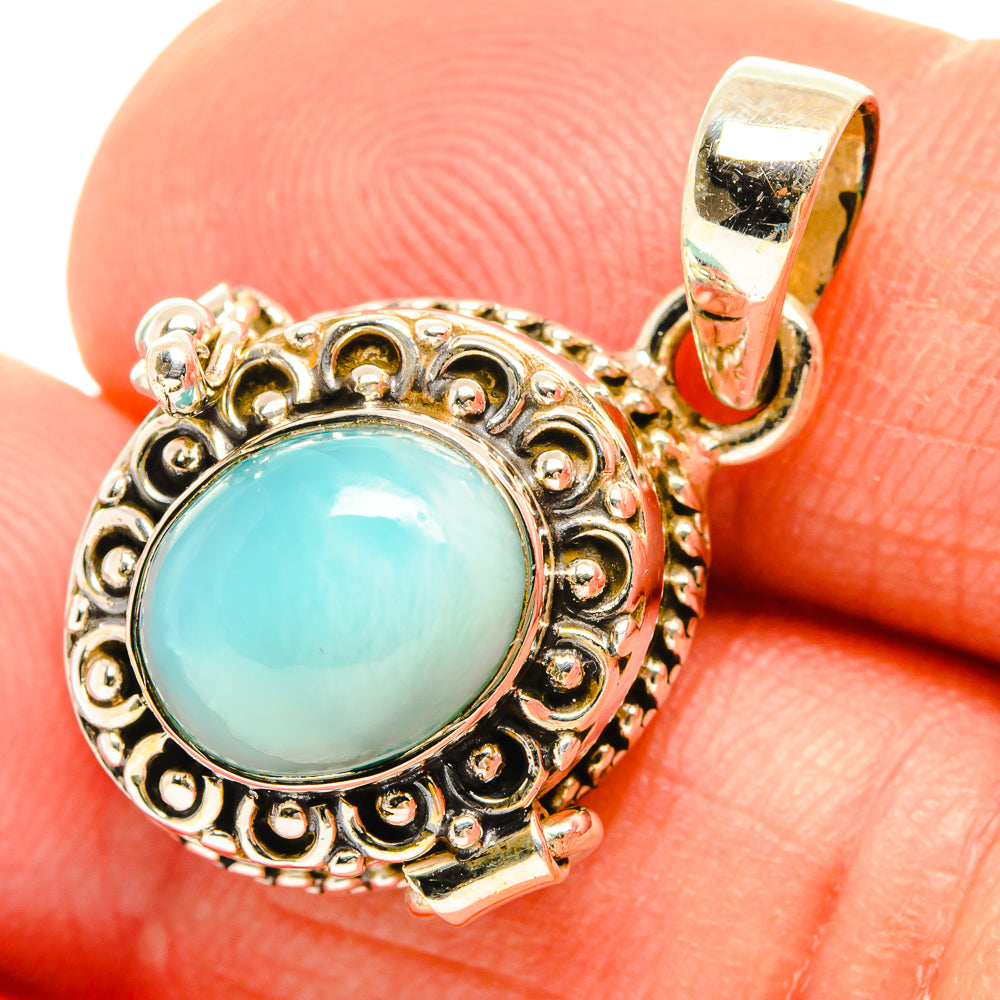 Round larimar pendant close-up, turquoise stone framed by decorative silver-tone setting