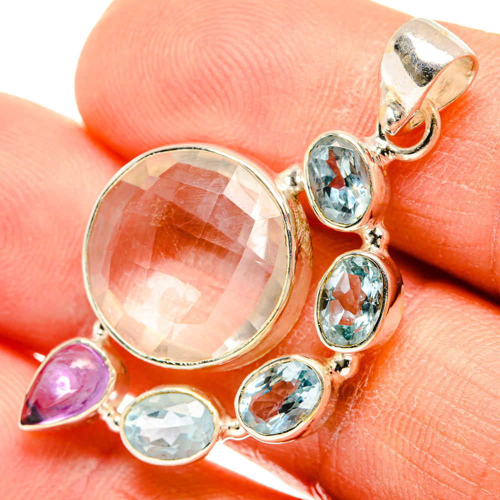 Sterling silver pendant close-up with round clear stone, blue ovals, and purple teardrop