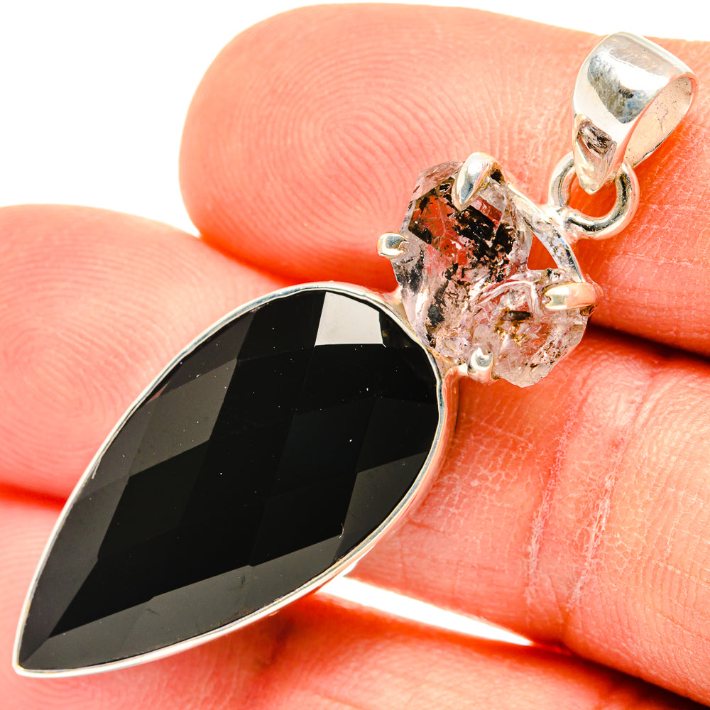 Closeup of black teardrop onyx pendant with silver prongs, herkimer diamond cluster