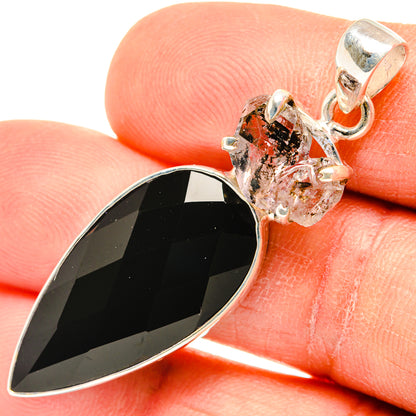 Closeup of black teardrop onyx pendant with silver prongs, herkimer diamond cluster