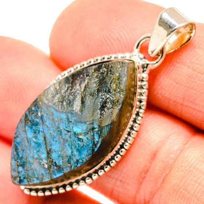 Close-up of rough blue labradorite pendant with silver bail and dotted edge bezel
