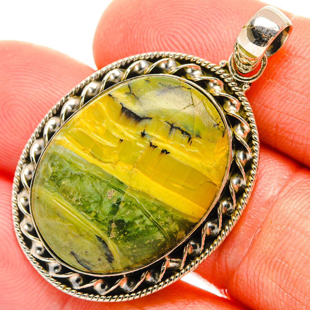 Oval green-yellow opal pendant with ornate sterling silver bezel and bail.