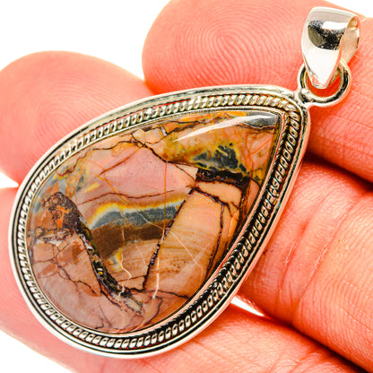 Teardrop jasper pendant close-up on chain bail, silver bezel with textured border