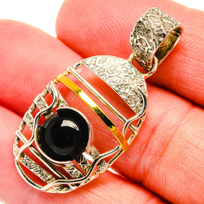 Black onyx oval pendant in filigree silver frame with gold stripe detailing