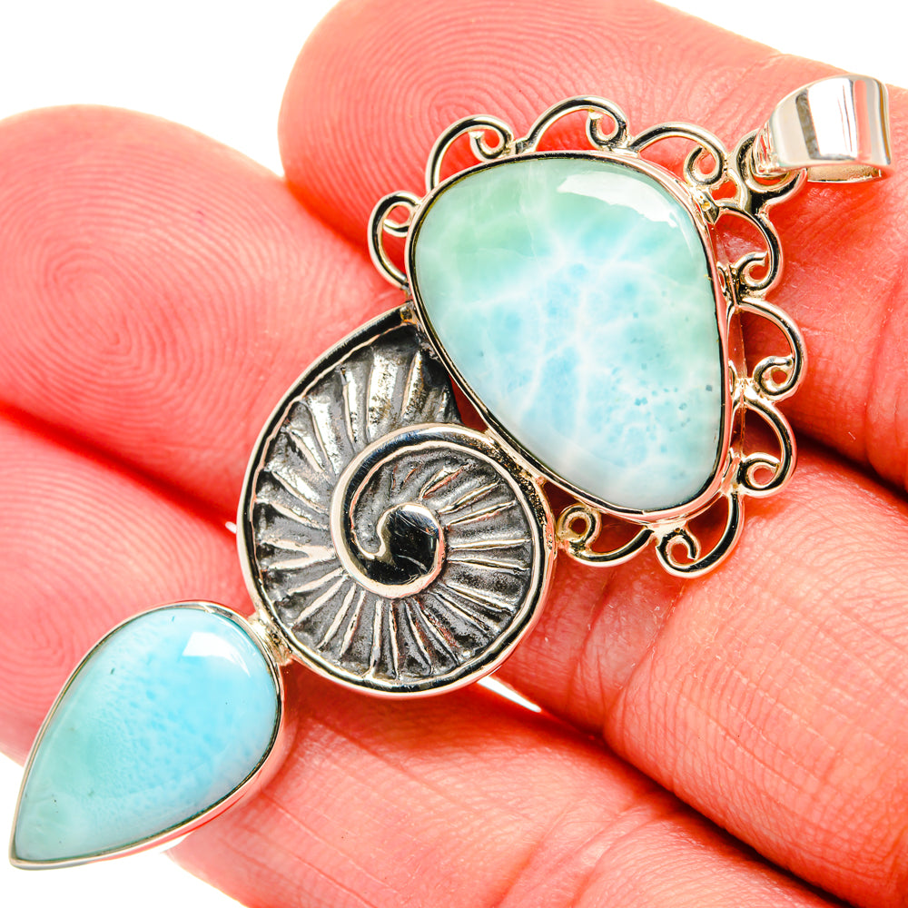 Oval larimar pendant with ornate silver frame, sunburst charm, and teardrop larimar detail