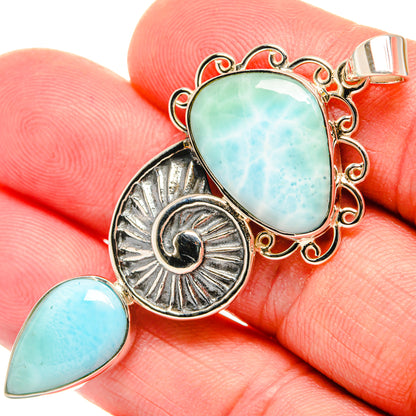 Oval larimar pendant with ornate silver frame, sunburst charm, and teardrop larimar detail