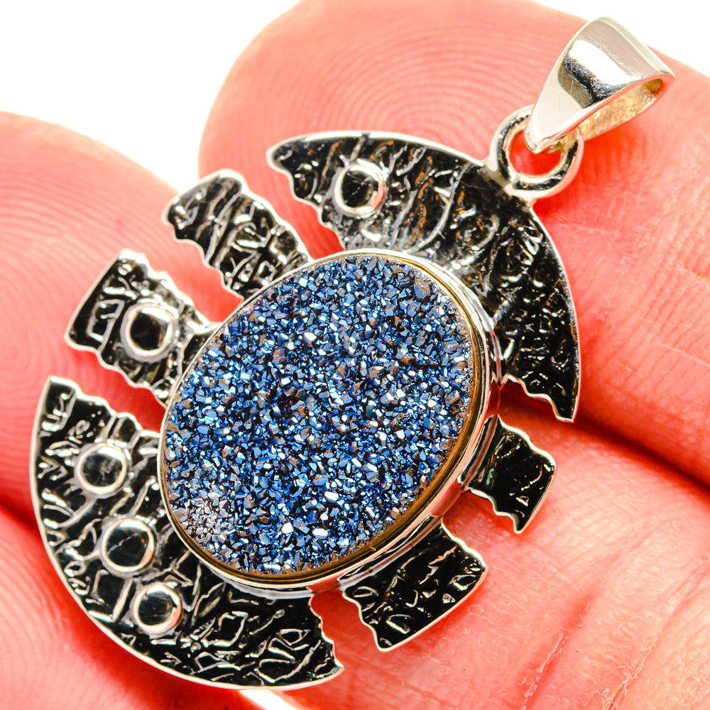 Oval blue druzy pendant in textured 925 silver frame with bail loop.