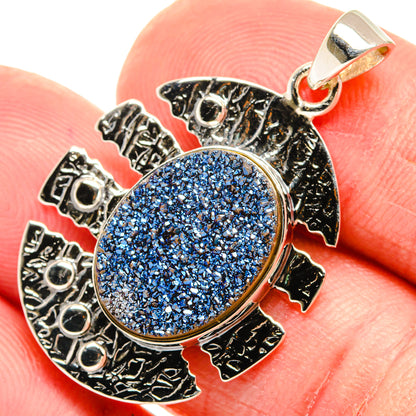 Oval blue druzy pendant in textured 925 silver frame with bail loop.