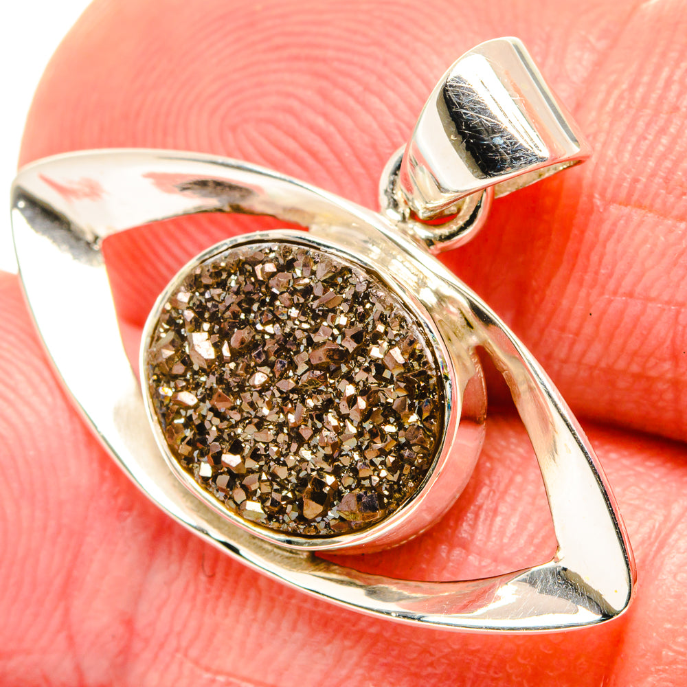 Sterling silver pendant with dark golden druzy center, oval setting and hinged bail