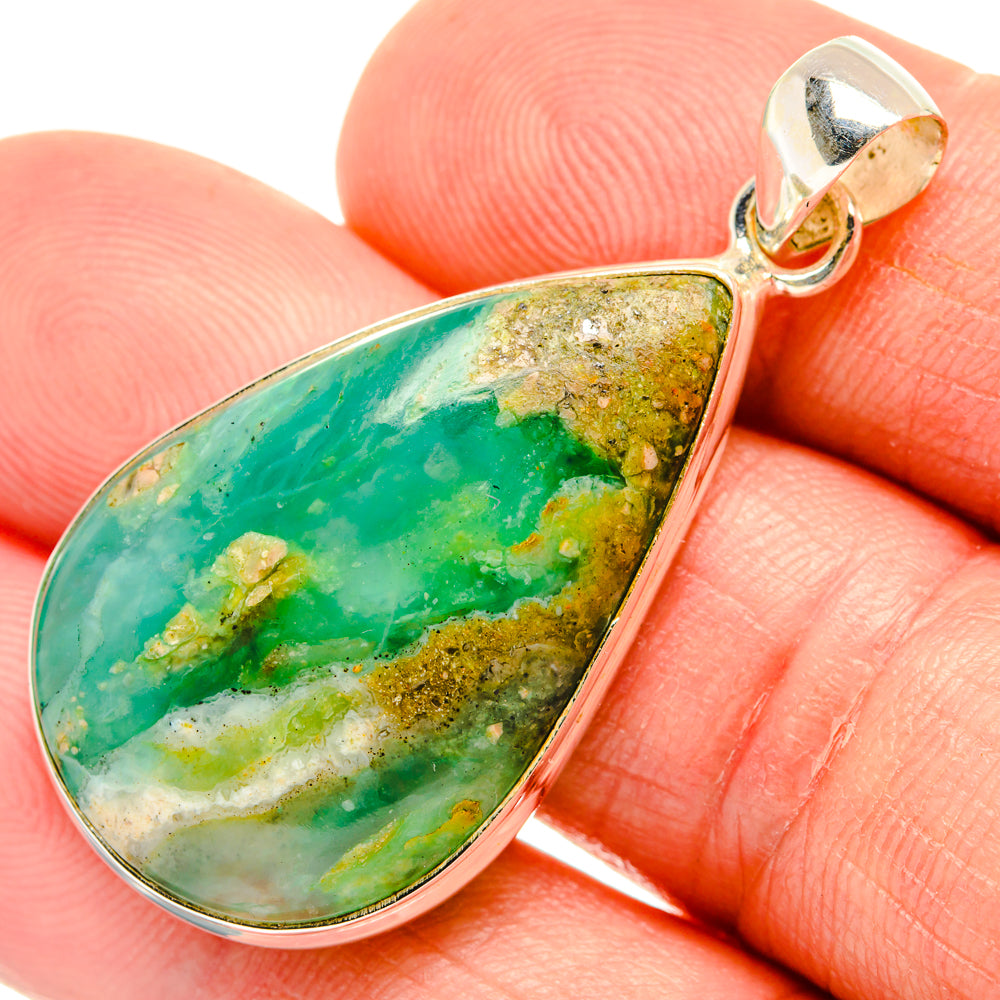 Teardrop green opal pendant detail in silver setting, close-up on gemstone surface