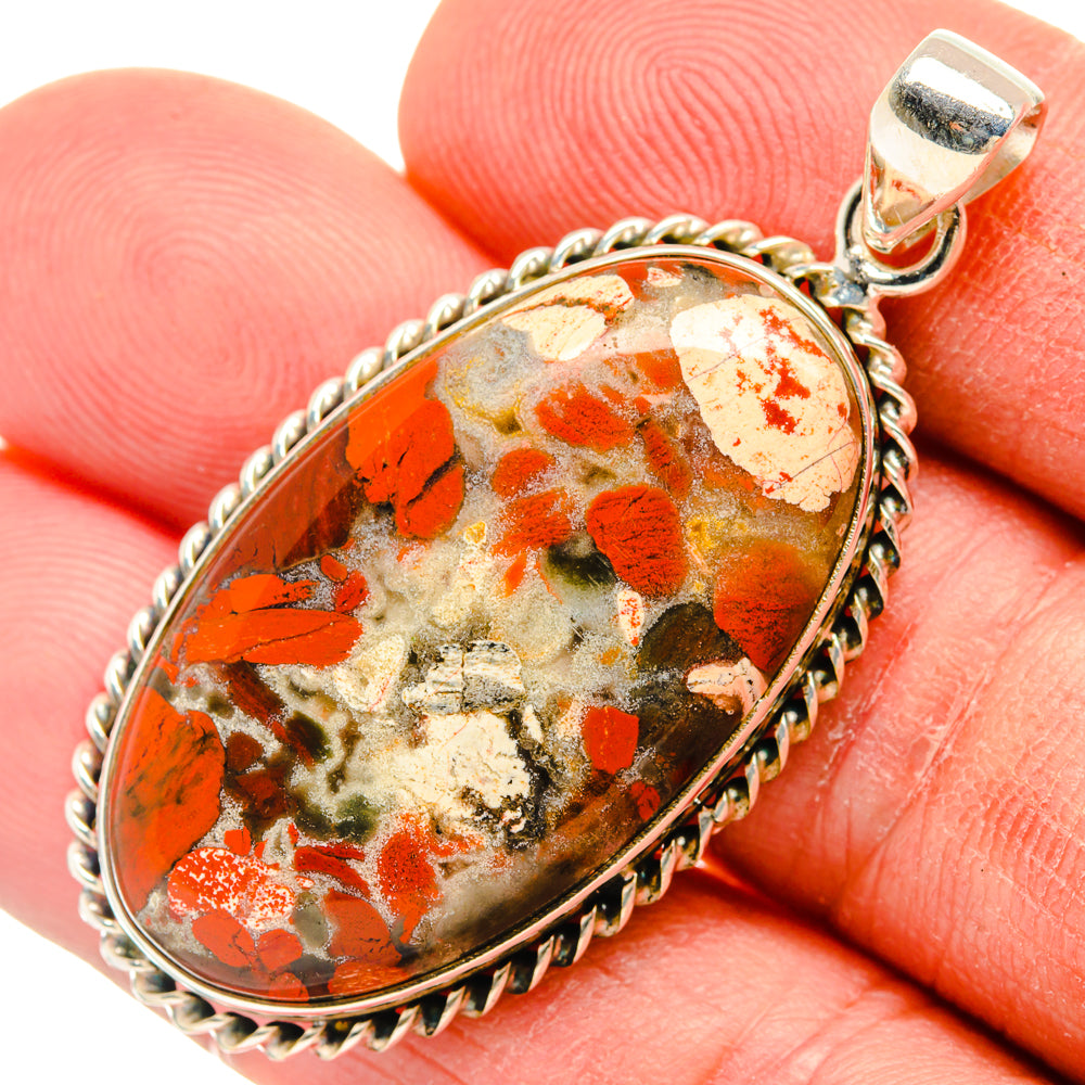 Close-up oval red jasper pendant in sterling silver bezel and bail, speckled pattern