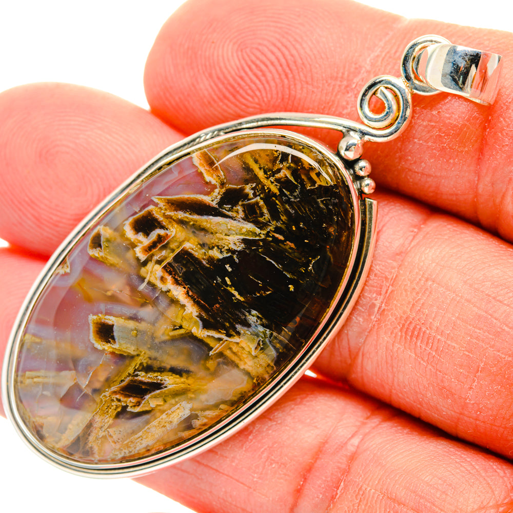 Oval amber and black agate pendant in silver bezel with loop bail