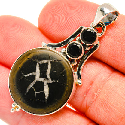 Septarian geode pendant, round black stone with gold matrix, silver setting and two black stones.