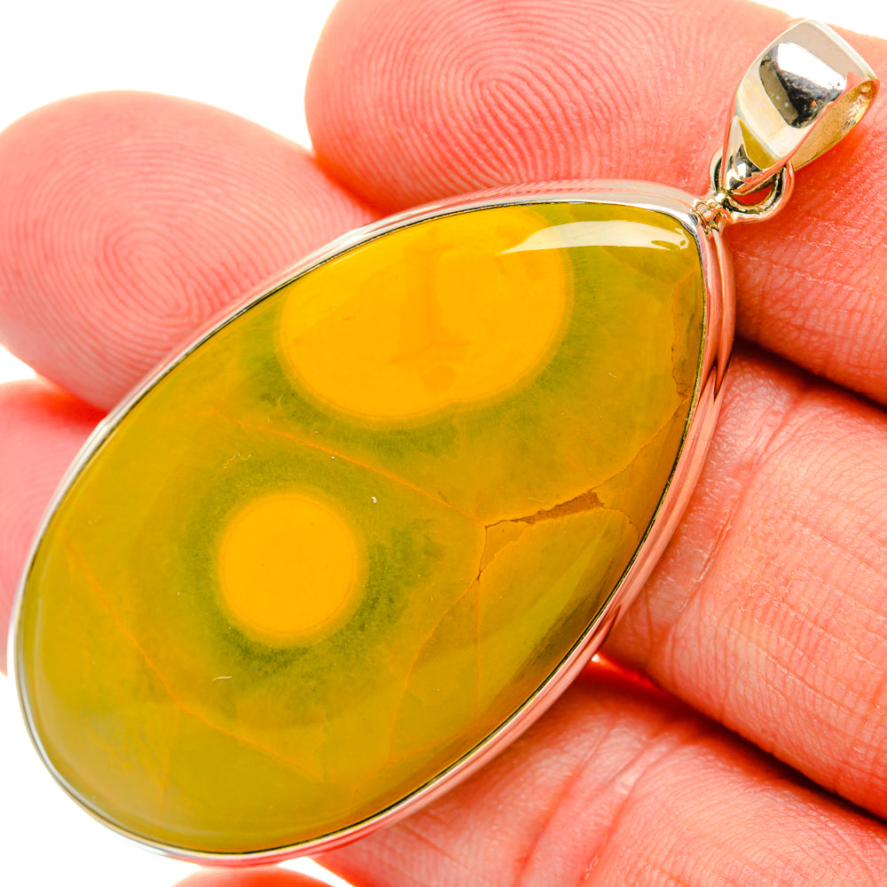 Ocean jasper teardrop pendant on finger, sterling silver bezel and bail