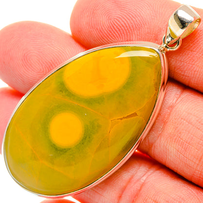 Ocean jasper teardrop pendant on finger, sterling silver bezel and bail