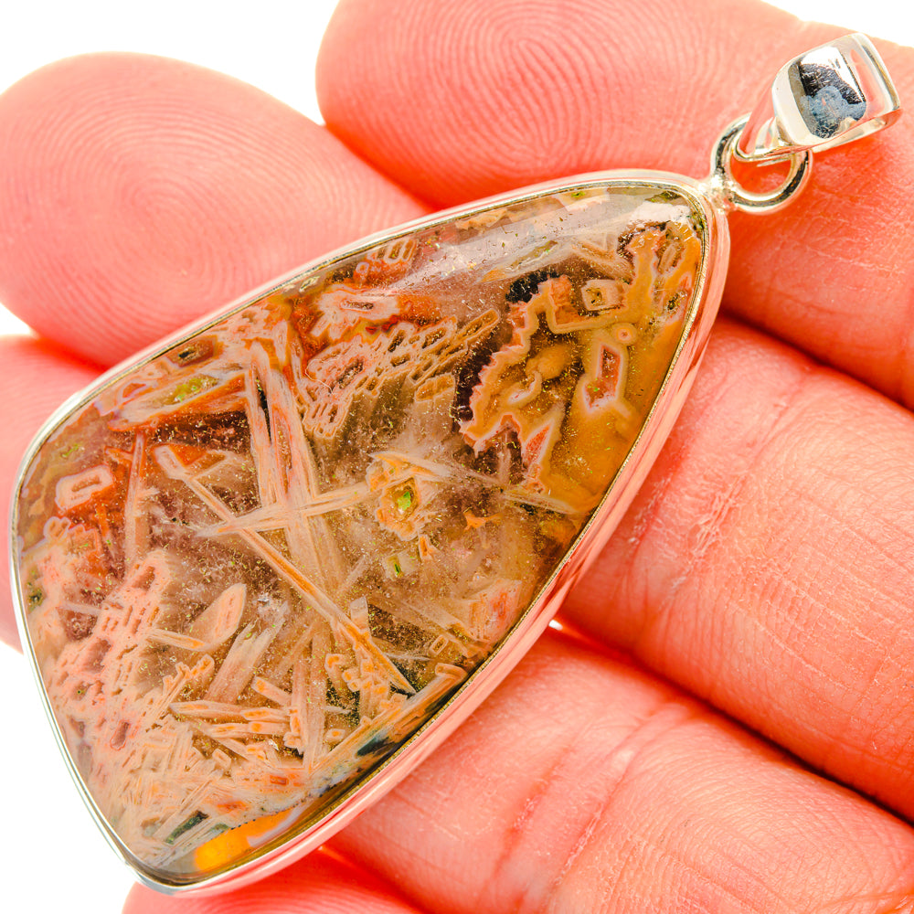 Triangular marbled agate pendant in amber, orange, and pink set in silver bezel