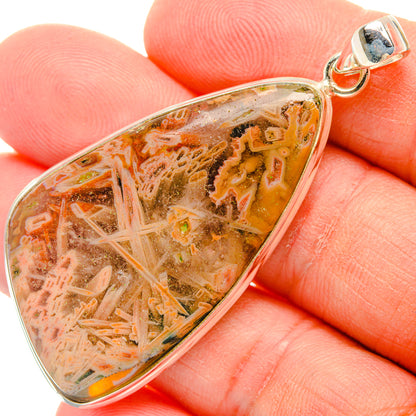 Triangular marbled agate pendant in amber, orange, and pink set in silver bezel