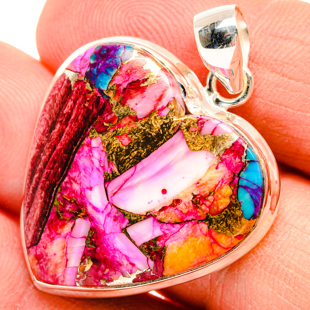 Heart-shaped multicolor gemstone pendant close-up with silver bail; pink, red, blue, gold