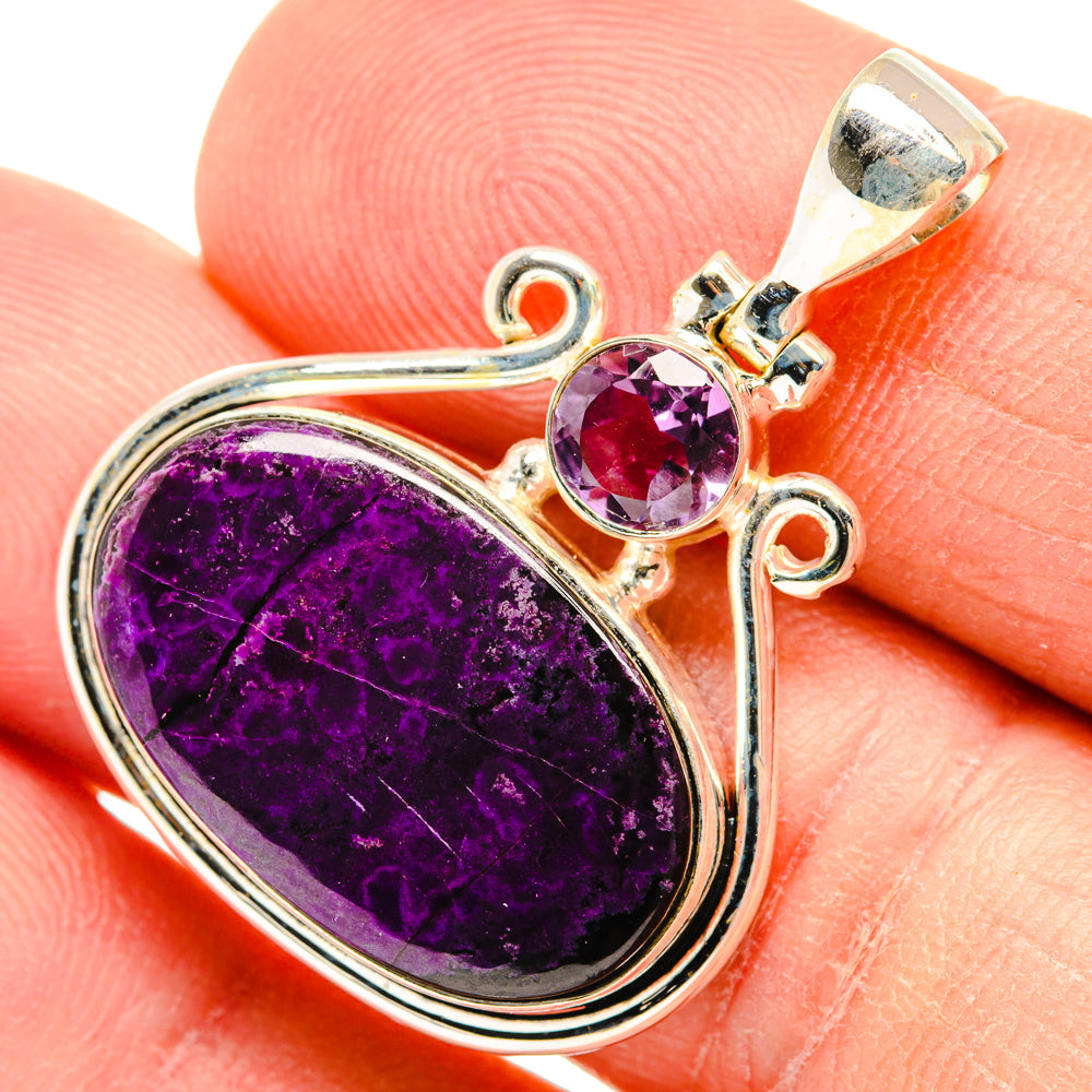 Silver pendant with oval purple cabochon, small round amethyst, and ornate top bail.