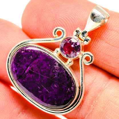 Silver pendant with oval purple cabochon, small round amethyst, and ornate top bail.