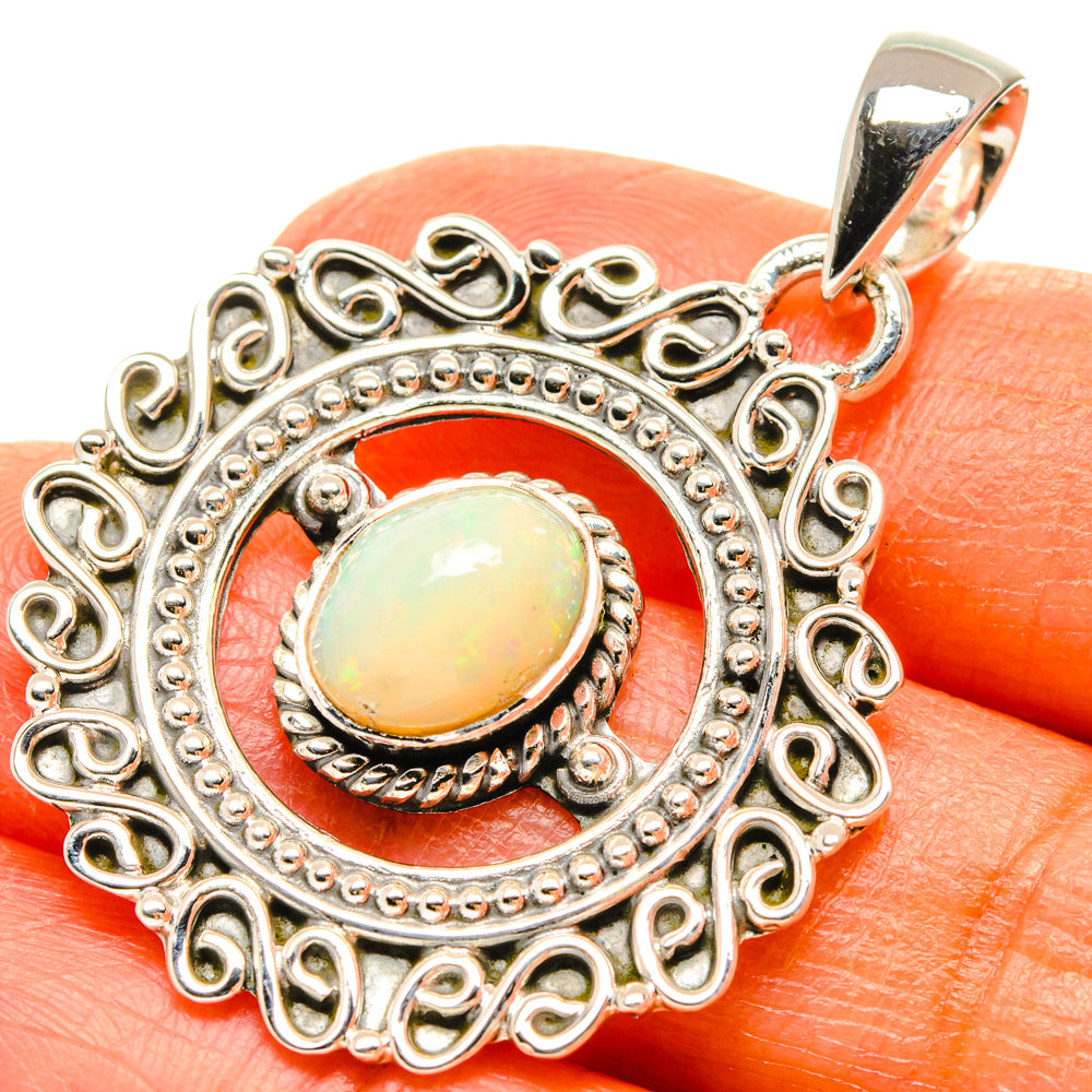 Sterling silver opal pendant with ornate filigree and oval yellow-gold stone