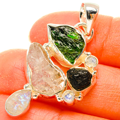 Sterling silver pendant with green center stone, black stone, and iridescent round accents