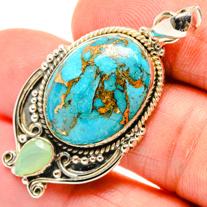 Close-up oval turquoise pendant with filigree silver frame and green teardrop charm