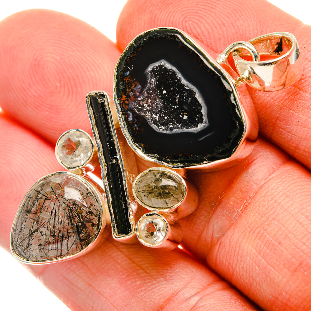 Black geode slice quartz pendant on silver chain bail; round clear stones and green accent.