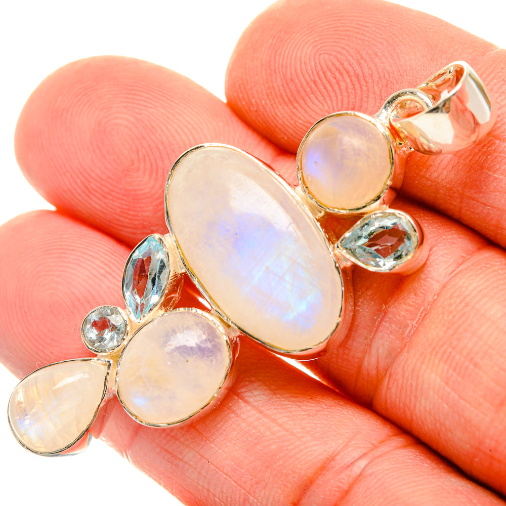 Gold-tone sterling silver pendant with oval opal-like stone and small blue accents