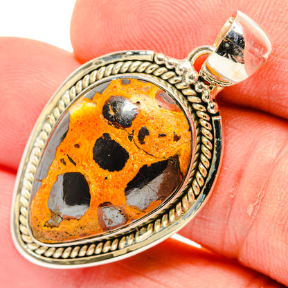 Bauxite pendant close-up: orange stone with black matrix in ornate sterling silver setting