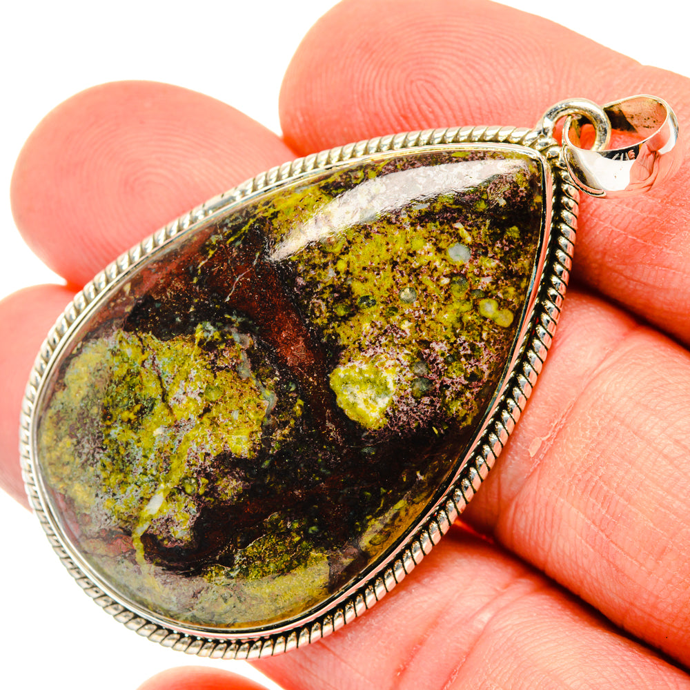 Oval 925 sterling silver pendant on finger, marbled green and dark stone cabochon