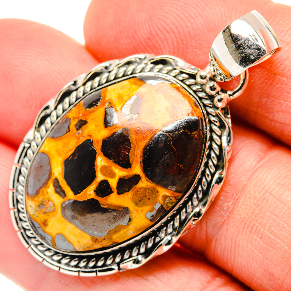 Close-up oval bauxite pendant in 925 sterling silver, amber/black stone with rope border