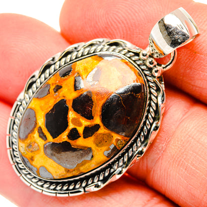 Close-up oval bauxite pendant in 925 sterling silver, amber/black stone with rope border