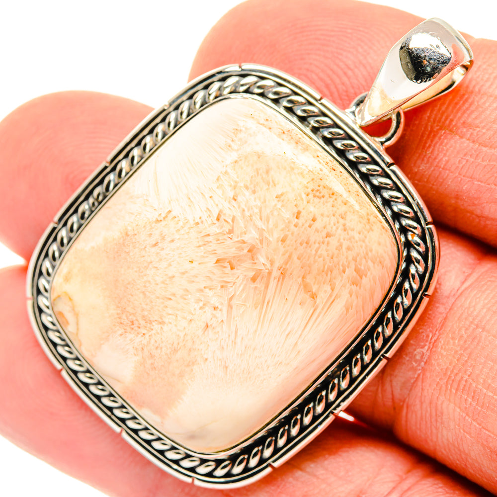 Sterling silver pendant bail with oval peach stone and ornate braided bezel