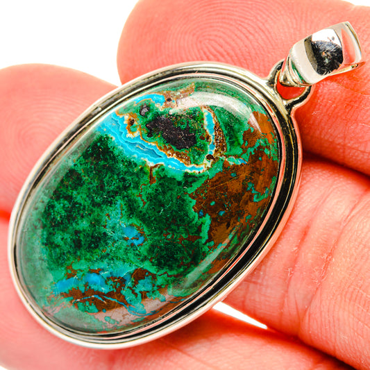 Oval sterling silver pendant with green-blue stone cabochon bezel, close-up detail.