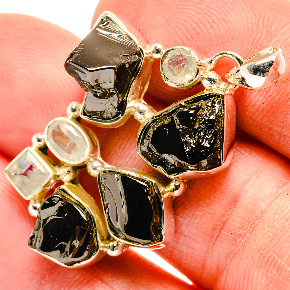 Sterling silver pendant closeup with black rough stones and round moonstone cabochons