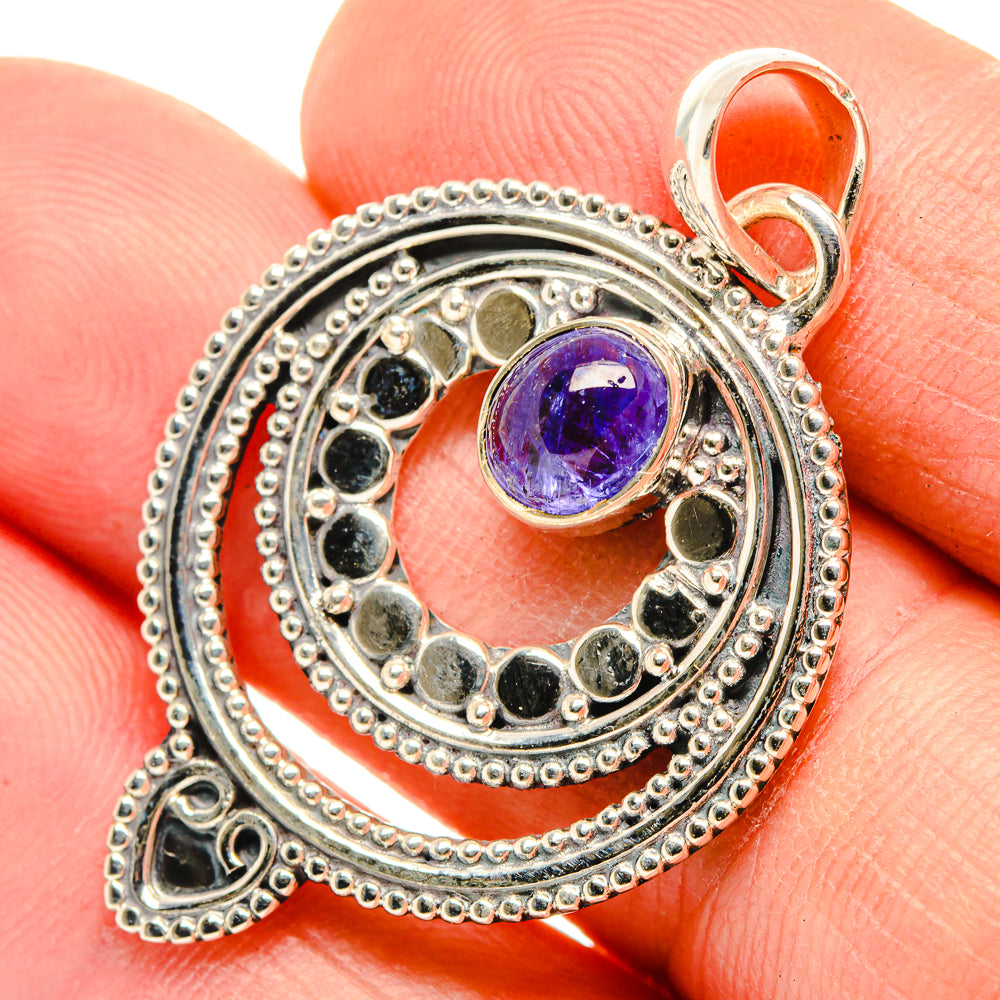 Sterling silver tanzanite pendant with round purple gemstone and textured circular frame